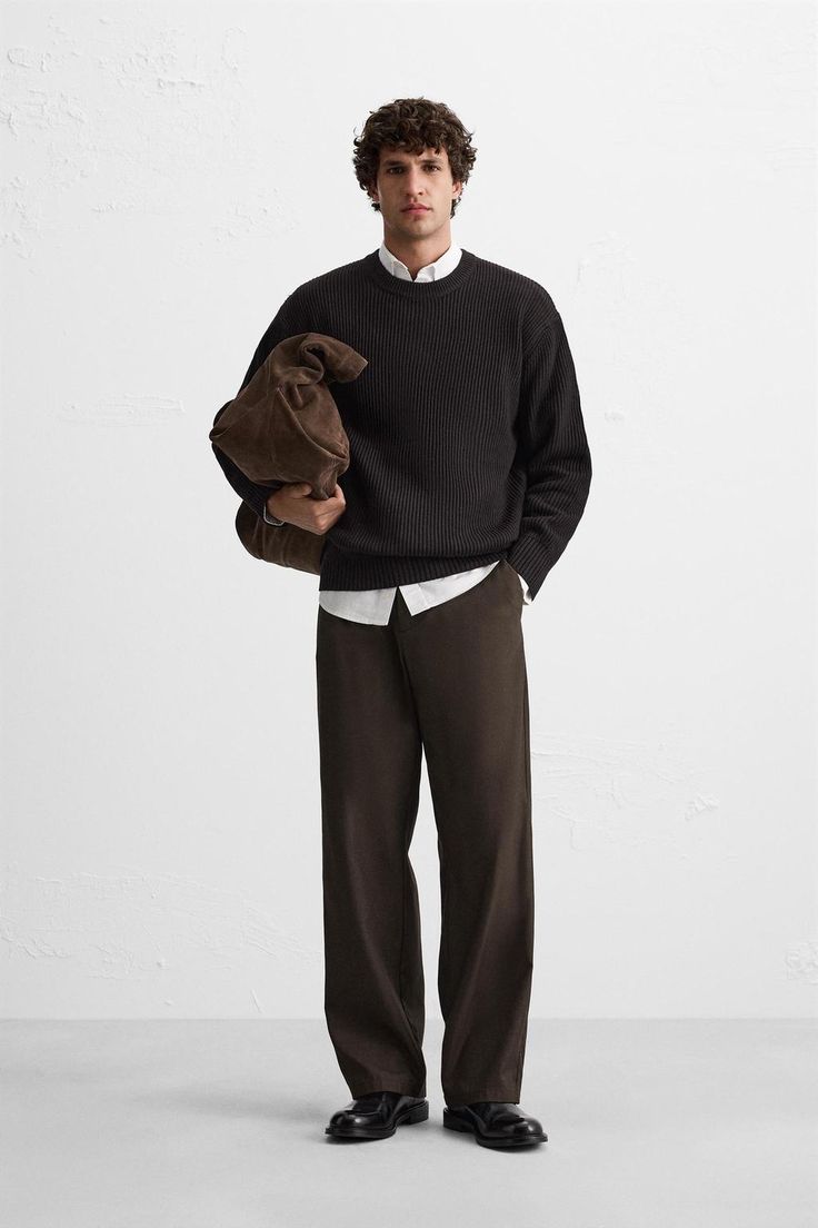 Dark ribbed jumper, white shirt and brown trousers with a suede bag